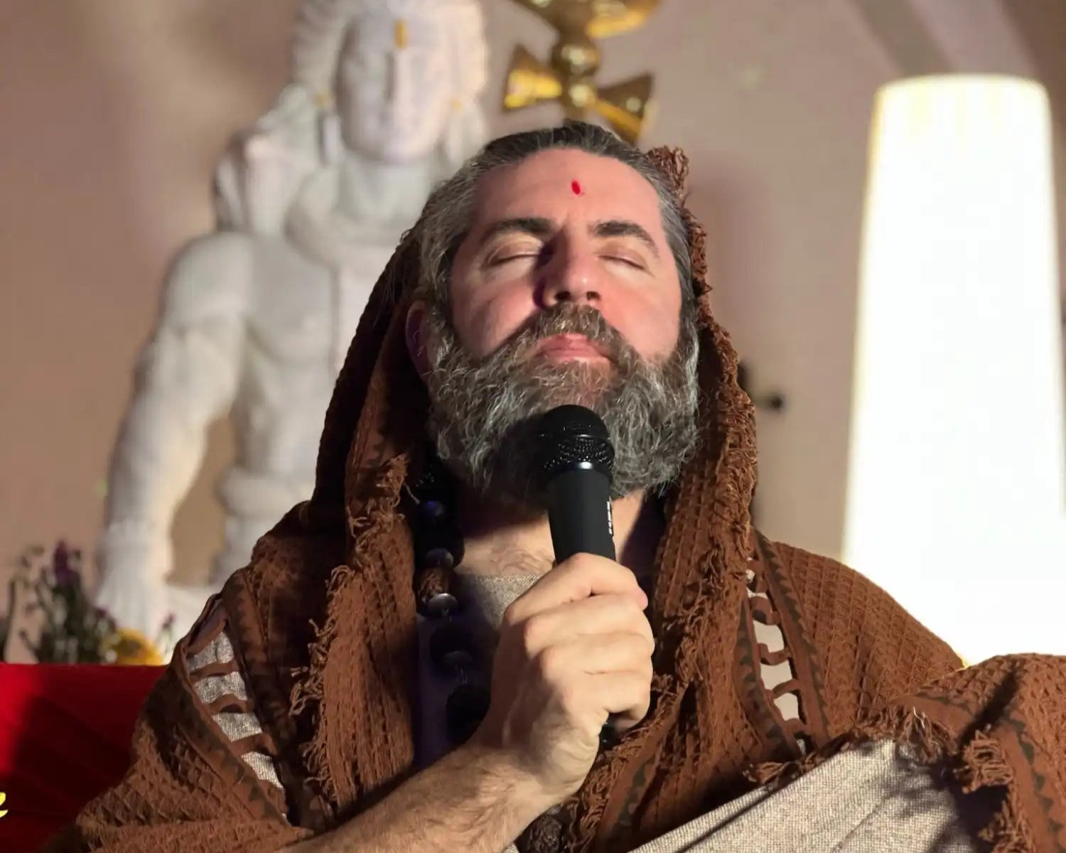 Bearded man holding microphone.
