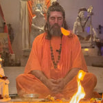 Meditating man in orange robe.