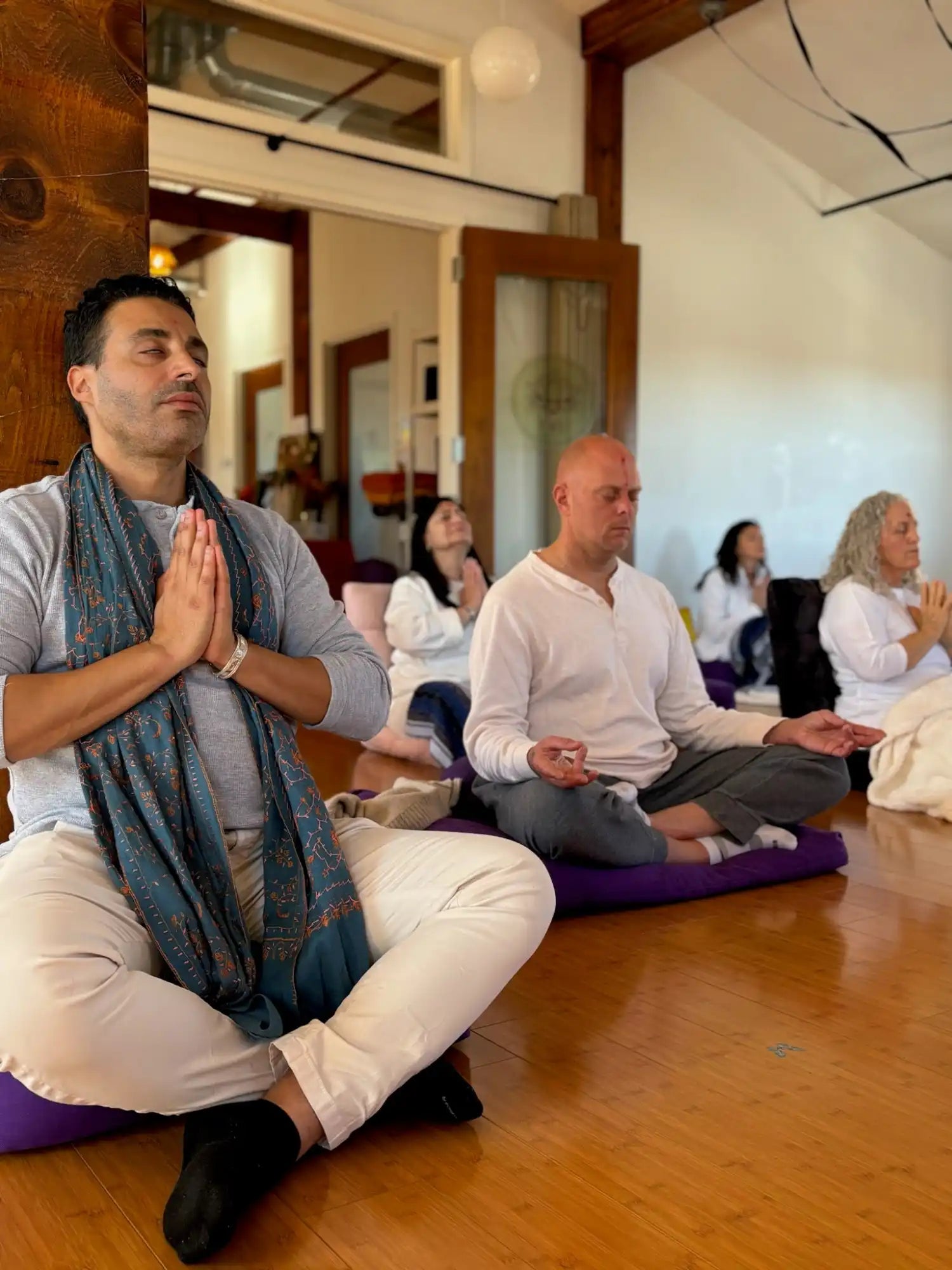 Meditating group on cushions.
