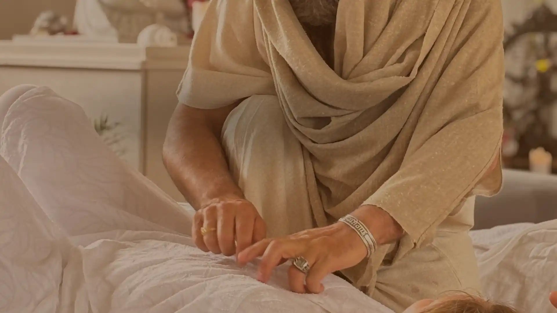 Hands touching a person’s back, possibly performing a massage or therapeutic touch.