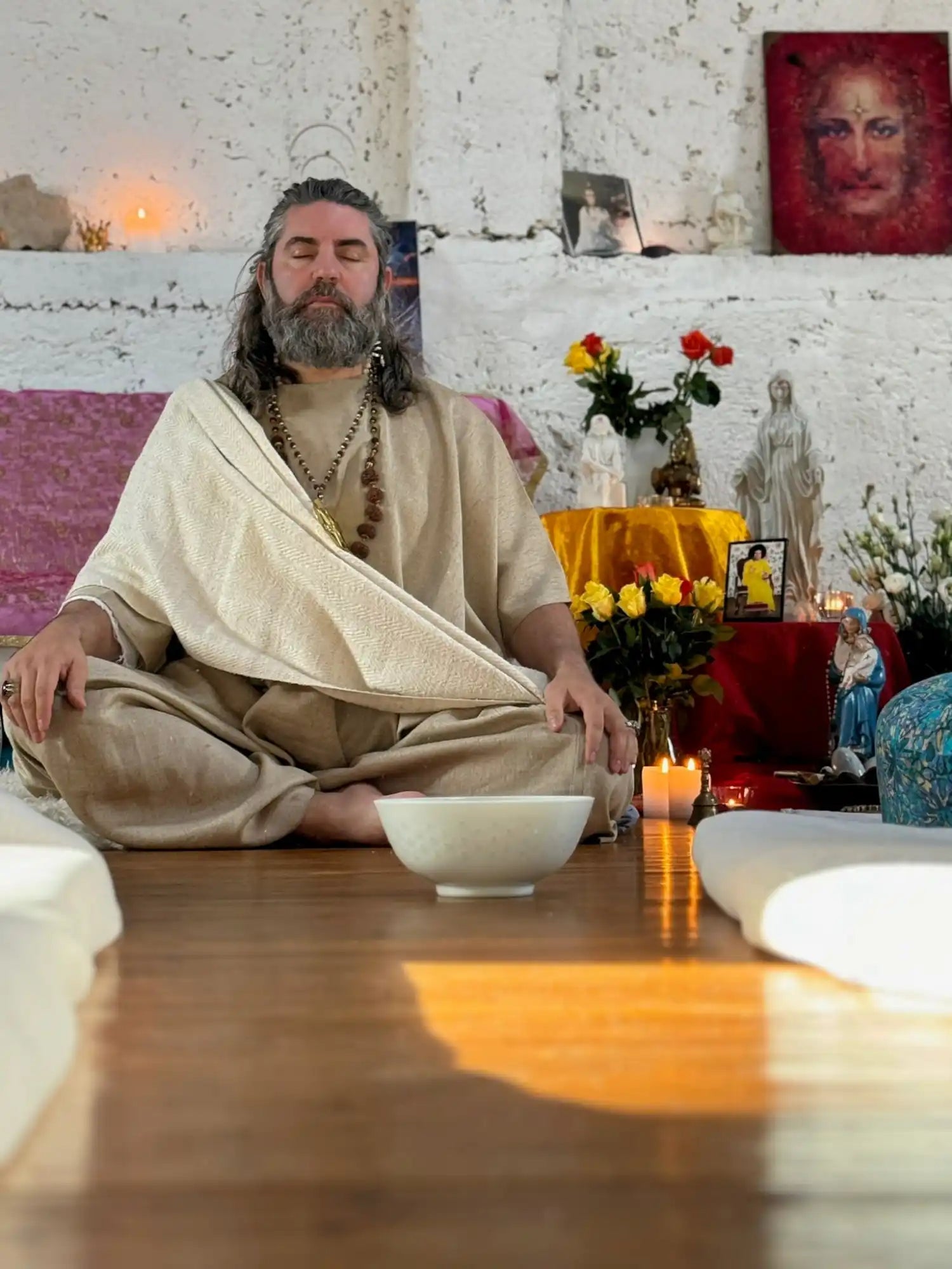 Meditating man in robe.