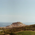 Ancient stone fortress perched atop a coastal hill.
