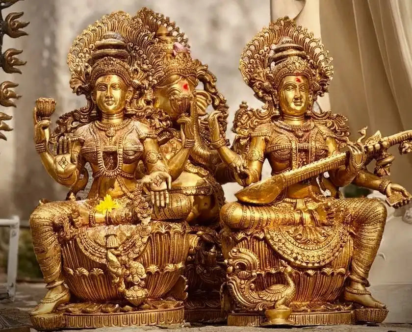 Golden statues of Hindu deities Lakshmi, Ganesha, and Saraswati.