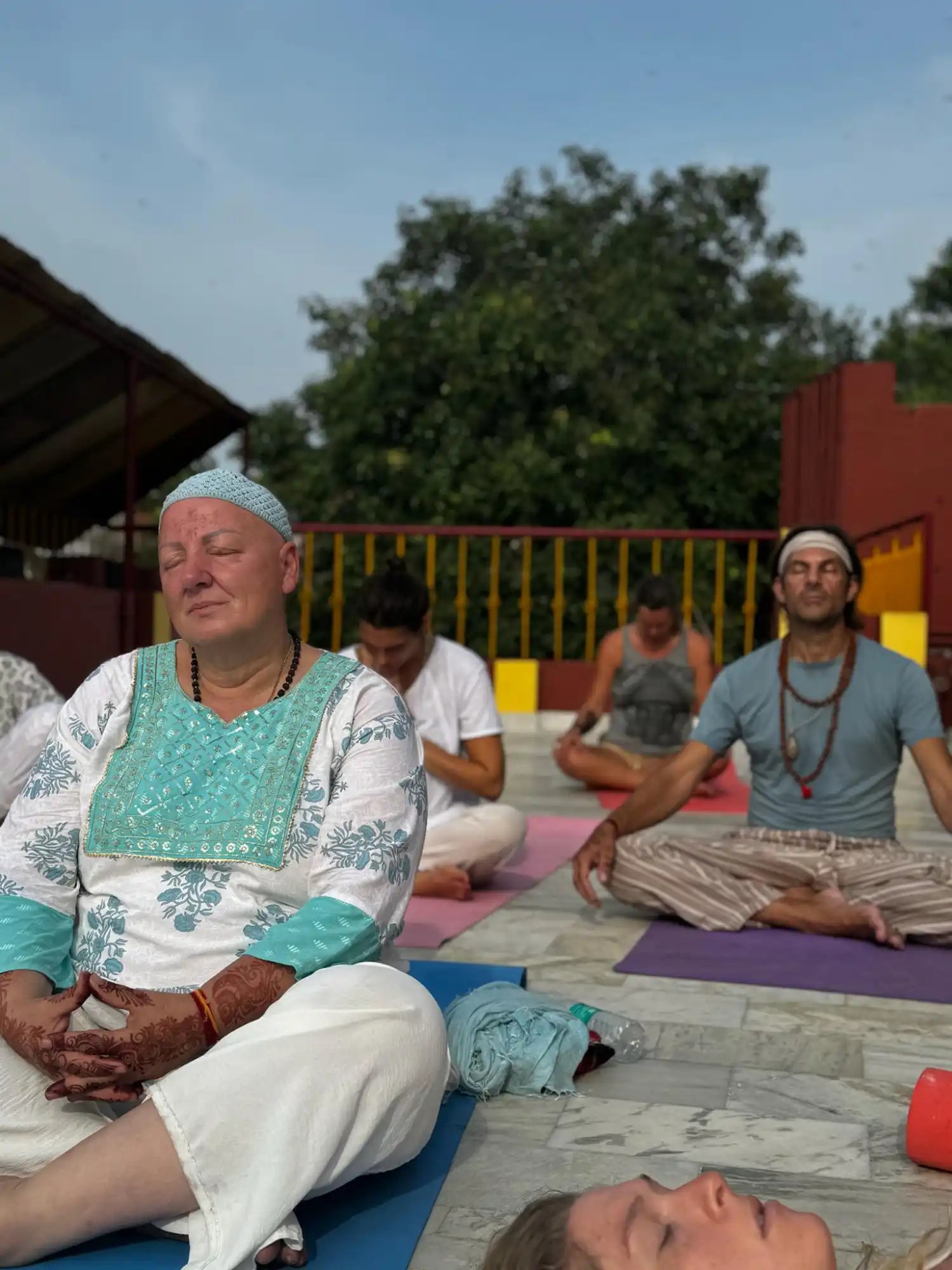 A group of people meditating outdoors.