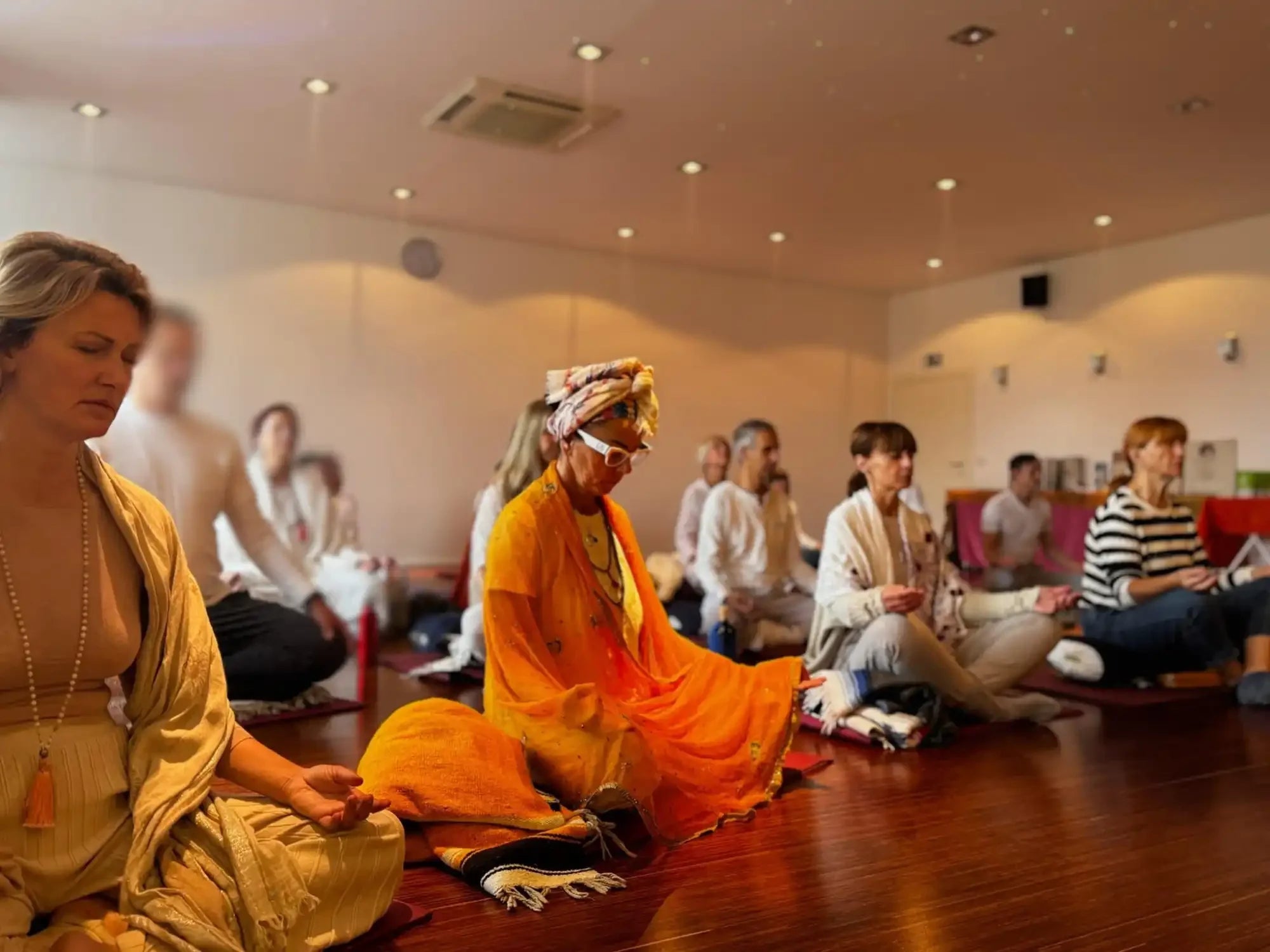 Group meditating indoors.