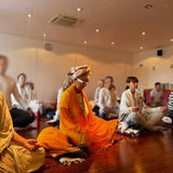 Group meditating indoors.