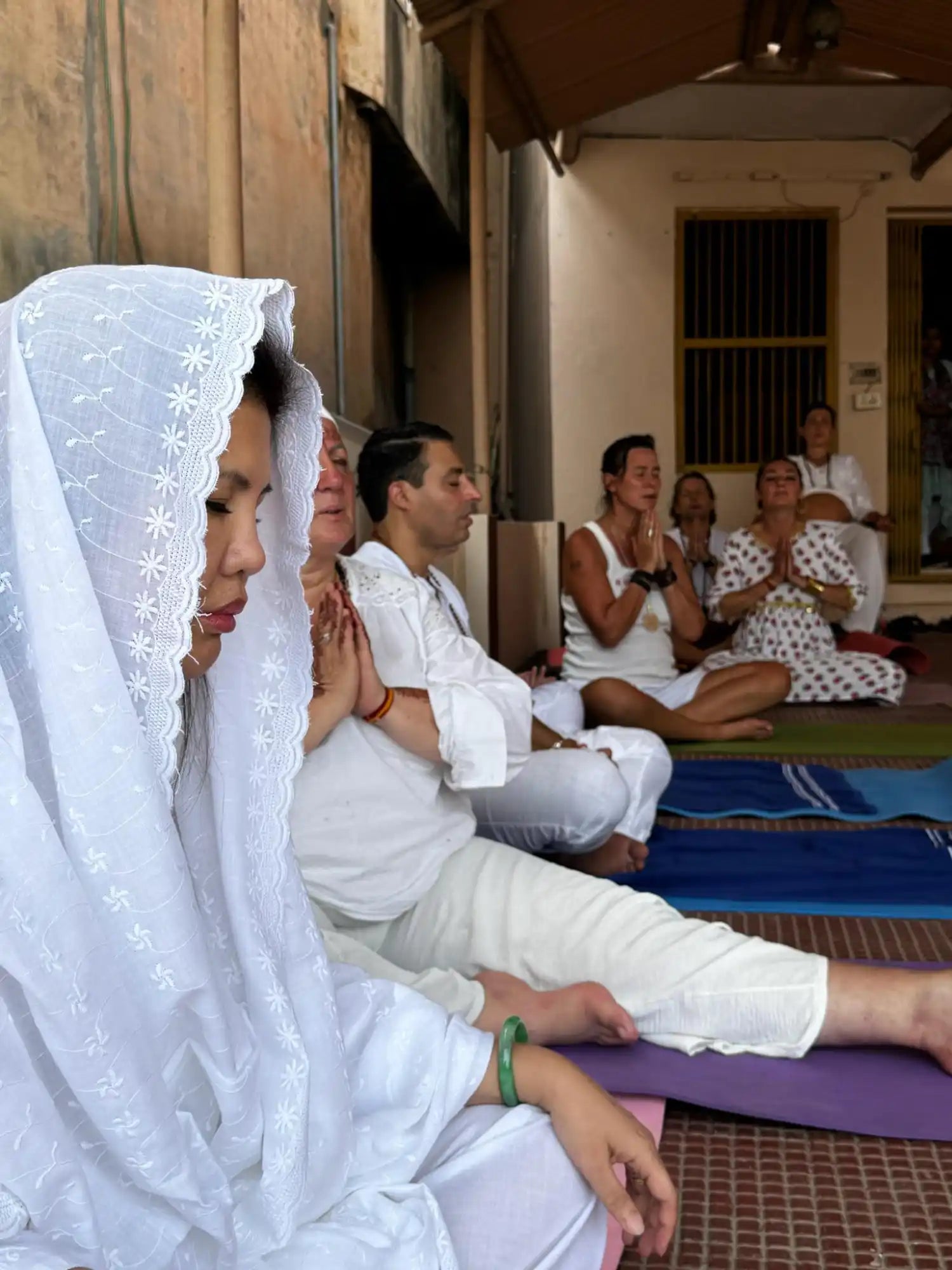 People meditating in white clothing.